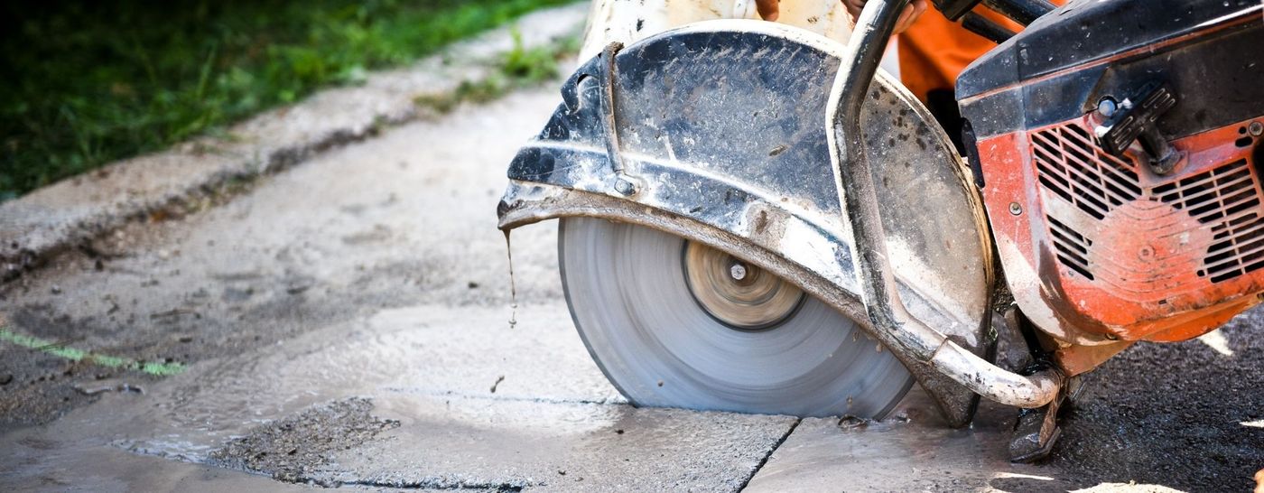 Hand saw cutting a straight line in a concrete slab